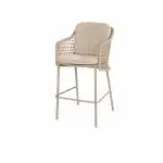 Ein Barhocker aus der Serie Tramonti von 4SO Gartenmöbel in Farbe Latte, mit geflochtener Rattan-Rückenlehne, weich gepolstertem Sitz und schlanken Metallbeinen mit Fußstützen. Modernes Design, fotografiert vor einem schlichten weißen Hintergrund.