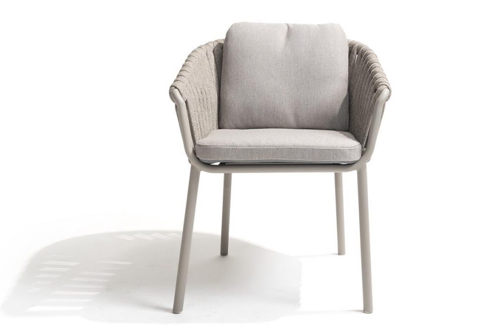 Ein moderner Stuhl von 4SO mit einem hellgrauen Kissen, gepolsterter Rückenlehne und Armlehnen. Das Metallgestell ist an den Seiten mit geflochtenen Seilen verziert und eignet sich perfekt als Gartenmöbel, um einen Hauch von Hamburger Stil in jeden Außenbereich zu bringen. Vor einem weißen Hintergrund.