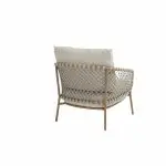 Ein moderner Living-Sessel aus der Serie Martinique von 4SO mit hellbraunem Holzrahmen und angewinkelten Beinen. Das geflochtene Seilmuster an der geschwungenen Rückenlehne und den Seiten passt hervorragend zu den dicken, hellbeigen Sitz- und Rückenkissen. Der Hintergrund ist schlicht weiß.