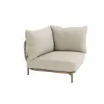 Eckmittelteil aus der Serie Martinique von 4SO mit hellbeigen Kissen, einem niedrigen Holzgestell, schlanken Metallbeinen und geflochtenen Rattan-Details. Dieses Modular-Lounge-Sofa Mittelteil fügt Komfort und Stil vor einem weißen Hintergrund hinzu.