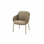 Der Serie Biarritz Dining Stuhl ist ein moderner Sessel mit hellbraunen Metallbeinen, beigen Sitz- und Rückenkissen und Armlehnen mit einem offenen, geflochtenen Gittermuster. Der Stuhl ist vor einem schlichten weißen Hintergrund abgebildet.