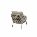 Ein moderner Low-Dining-Stuhl mit einem Kissen in Farbe terre. Die Rückenlehne und die Seiten des Stuhls weisen ein gewebtes geometrisches Muster auf, das von vier schlanken schwarzen Metallbeinen getragen wird, aus der Serie Mallorca von 4SO. Vor einem weißen Hintergrund.