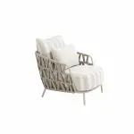 Geflochtener Living-Sessel aus der Serie Beverly von 4SO mit einem beigen Gestell mit breiten, angewinkelten Beinen. Creme- und beigefarbene, gestreifte Kissen und ein unifarbenes Lendenkissen ergänzen das offene Kreuzgeflecht an den Seiten und im Rücken.