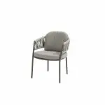 Dieser moderne Calma von 4SO in Terre ist ein minimalistischer Dining-Stuhl mit einem gepolsterten Sitz, geflochtenen geschwungenen Armlehnen und schlanken dunklen Beinen - perfekt als elegantes Gartenmöbel vor einem schlichten weißen Hintergrund.