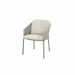 Ein moderner Diningstuhl aus der Serie Florence von 4SO mit hellbeiger gepolsterter Sitzfläche und Rückenlehne, dünnen Metallbeinen und offenen Seiten. Sein minimaler Rahmen und die Farbe Terre machen ihn zu einer stilvollen Ergänzung für jedes moderne Gartenmöbel.