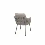 Ein moderner Dining-Stuhl aus der Serie Cannes von 4SO mit strukturierter Stoffrückenlehne und Sitzkissen in Farbe Terre. Er hat vier schlanke, gerade Metallbeine und eine geschwungene Rückenlehne, die sich in der schrägen Rückansicht vor weißem Hintergrund zeigt.