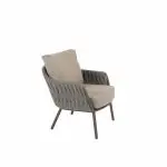 Der moderne Low-Dining-Stuhl aus der Serie Cannes von 4SO Gartenmöbel zeichnet sich durch einen geflochtenen Rahmen, abgewinkelte Metallbeine und dicke Kissen in Farbe Terre aus, die vor einem schlichten weißen Hintergrund stehen.